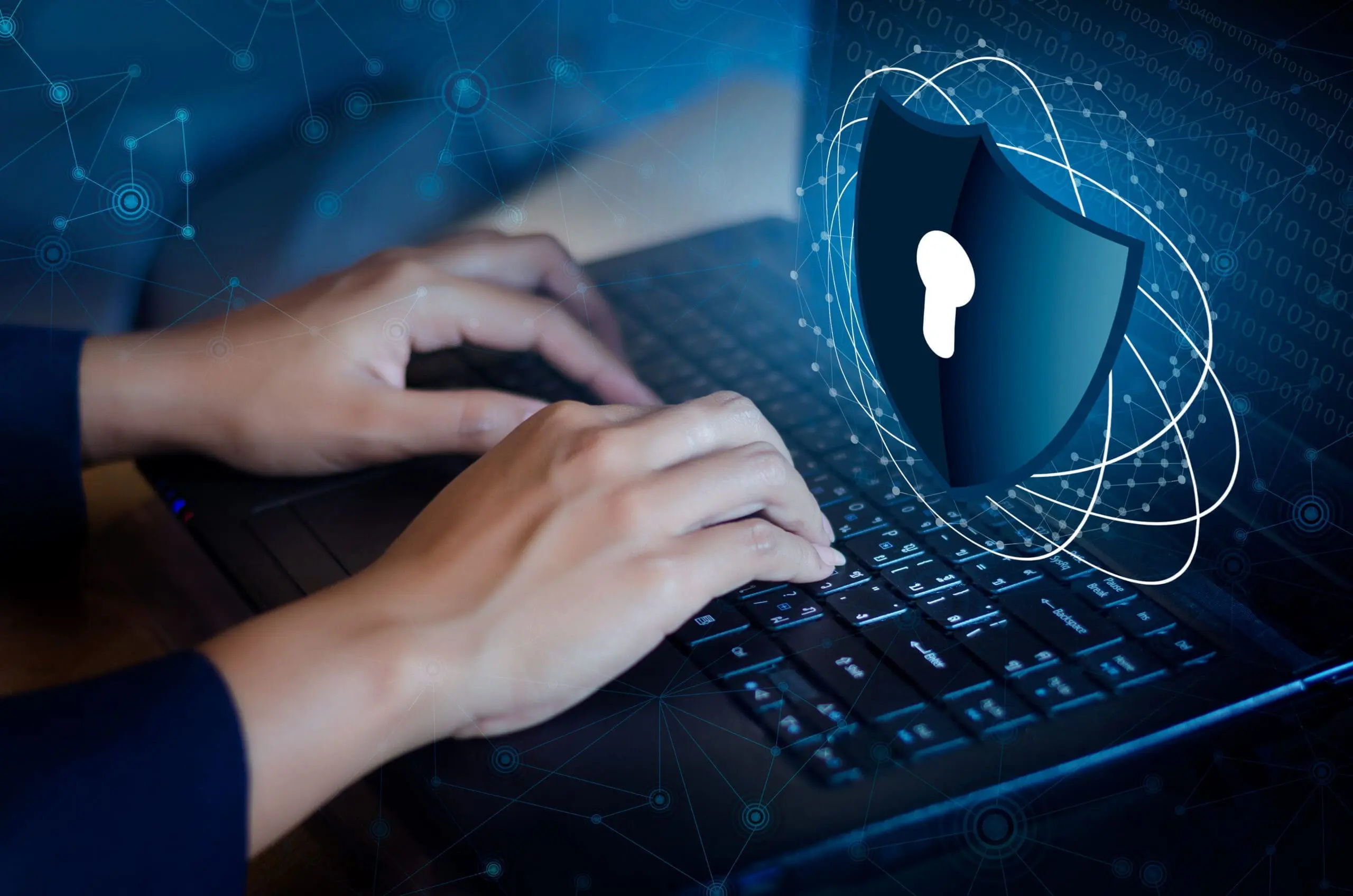 Woman typing on her laptop, with Shield cyber Key lock