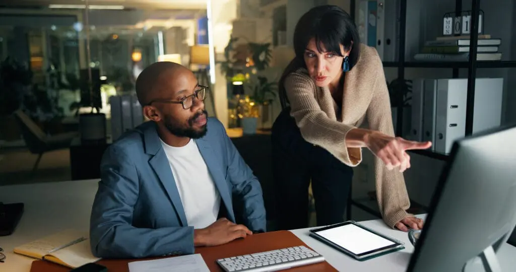 Business, people and explain with computer at night for training, finance report and budget. Staff, pc and coaching for audit