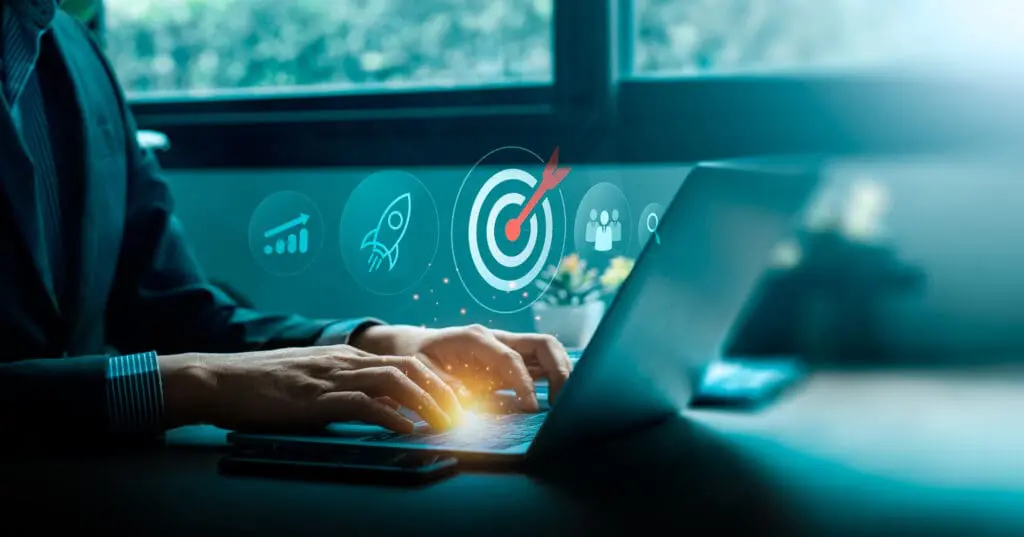 Business goal and digital strategy success concept with businessman typing on laptop computer and futuristic target icon surr