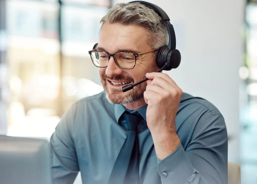 Senior, happy man and call center with headphones in customer service, support or telemarketing at office. Mature businessman